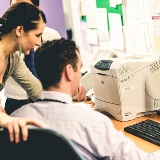 Doctor pointing at file on computer screen